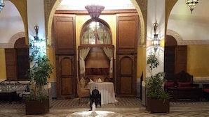 A lobby with a central fountain, ornate arches, and patterned tile flooring. - Palais Didi (Meknes)