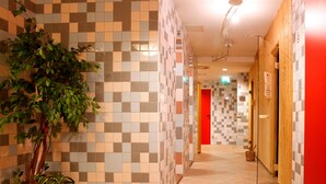 A hallway with tiled walls and a wooden door.