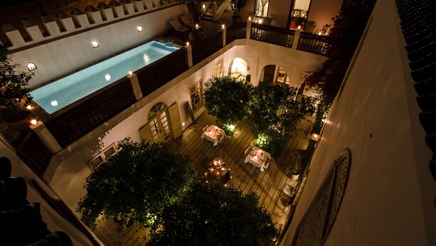 A courtyard with a swimming pool, outdoor seating, and a staircase. - Riad Clémentine (Marrakech)