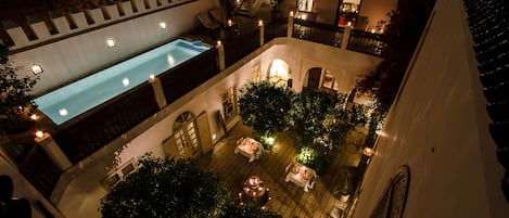 Een buitenzwembad, parasols bij het zwembad en ligstoelen