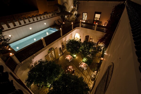 Una piscina al aire libre, sombrillas, sillones reclinables de piscina