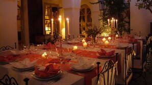 A dining area with tables set for a meal, featuring candles and a warm ambiance. - Riad Clémentine (Marrakech)