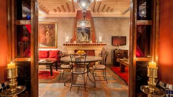 A dining area with a round table, chairs, and a chandelier.