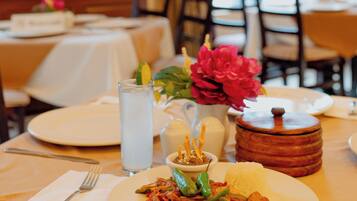 A dining table set with plates of food, a pitcher, and a salt and pepper shaker.