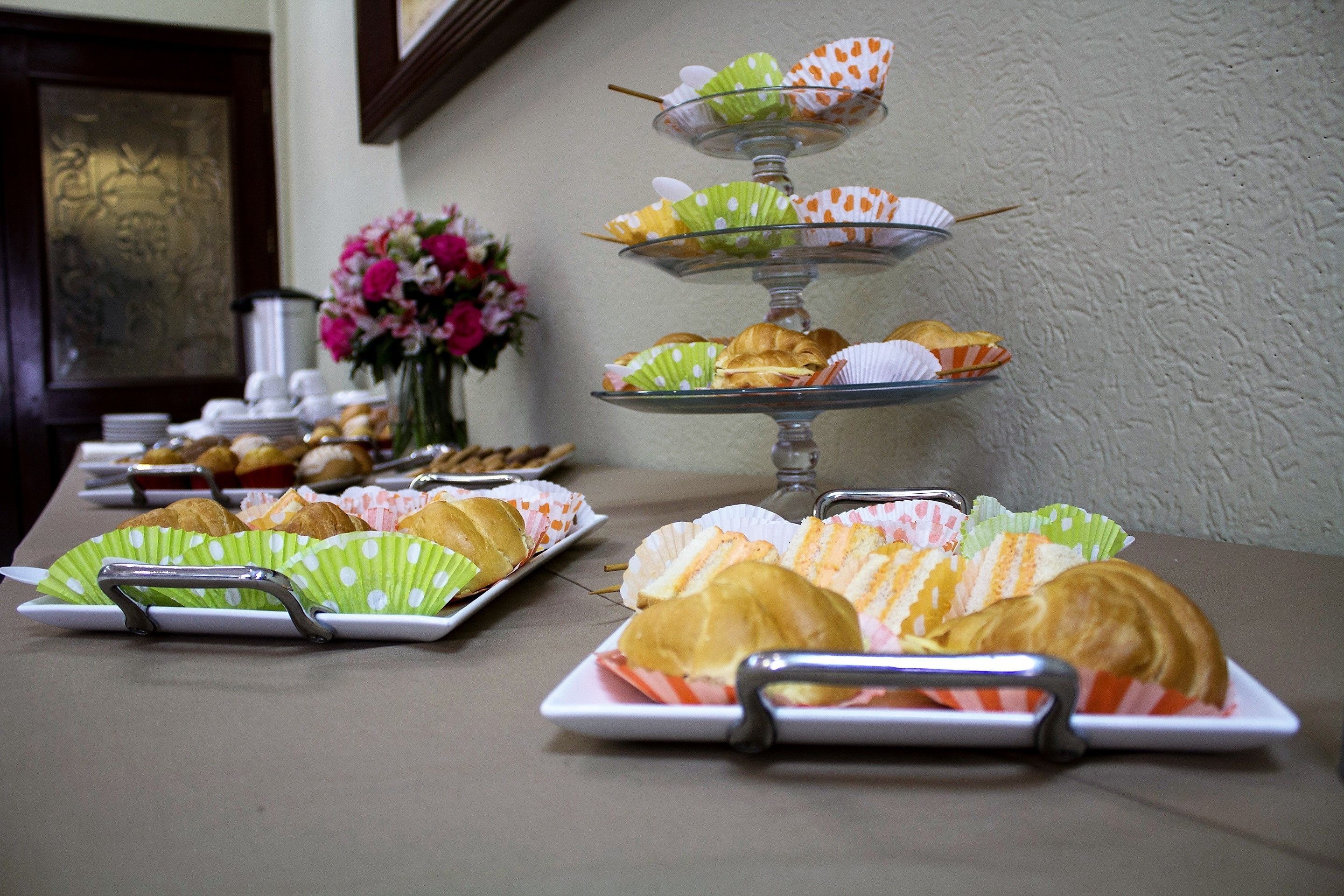 Una mesa de buffet con diversos pasteles y sándwiches.