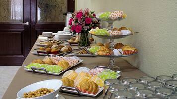 Une table de buffet avec divers plats et des verres vides.