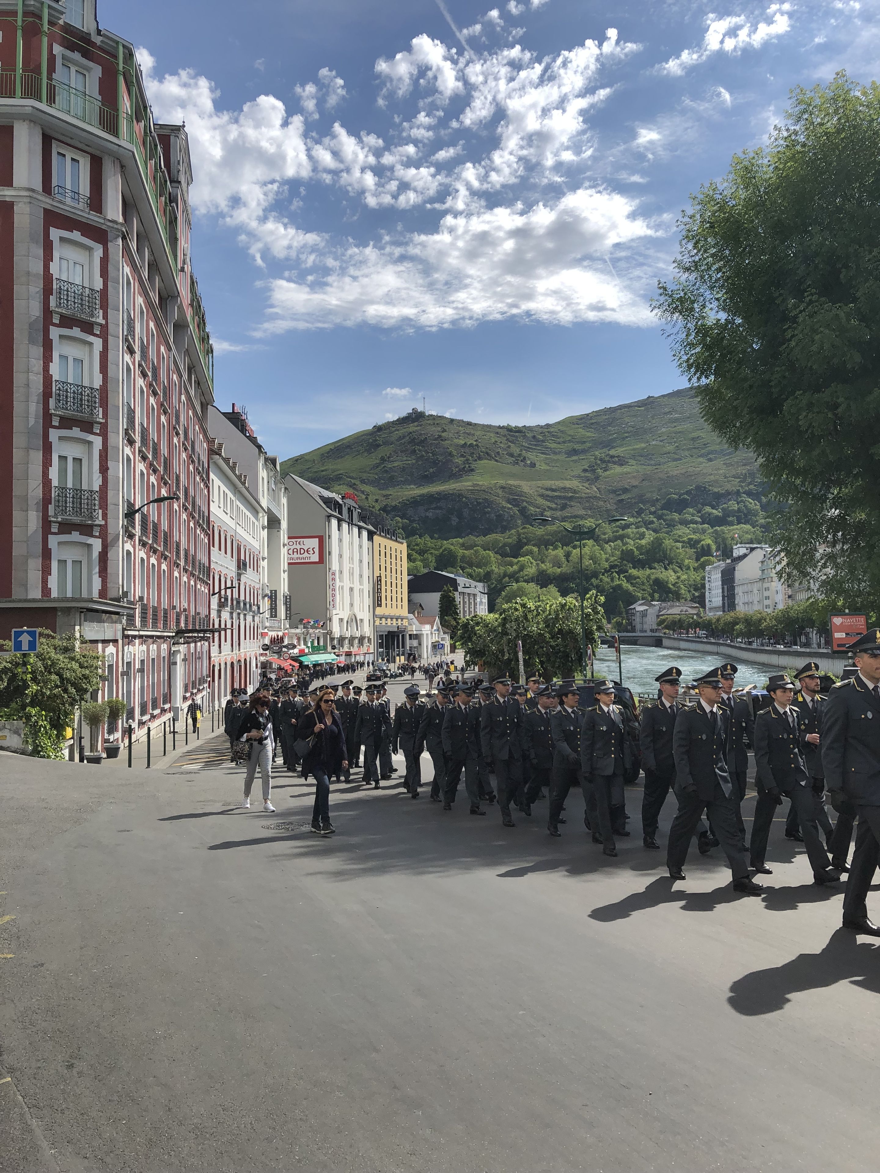 Une rue où l’on voit un groupe d’agents en uniforme défiler.