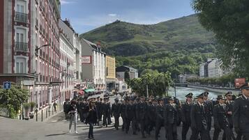 Une rue où l’on voit un groupe d’agents en uniforme défiler.