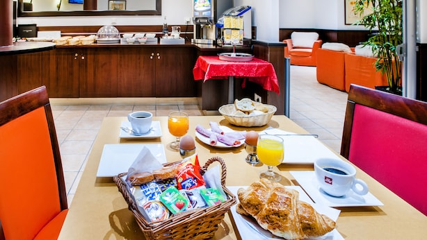 A breakfast buffet with various food items, a coffee station, and seating arrangements. - Appart'hôtel Saint Jean (Lourdes)