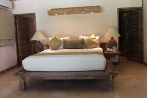 Un letto con struttura in legno, due comodini con lampade e un punto luce a parete sopra il letto.