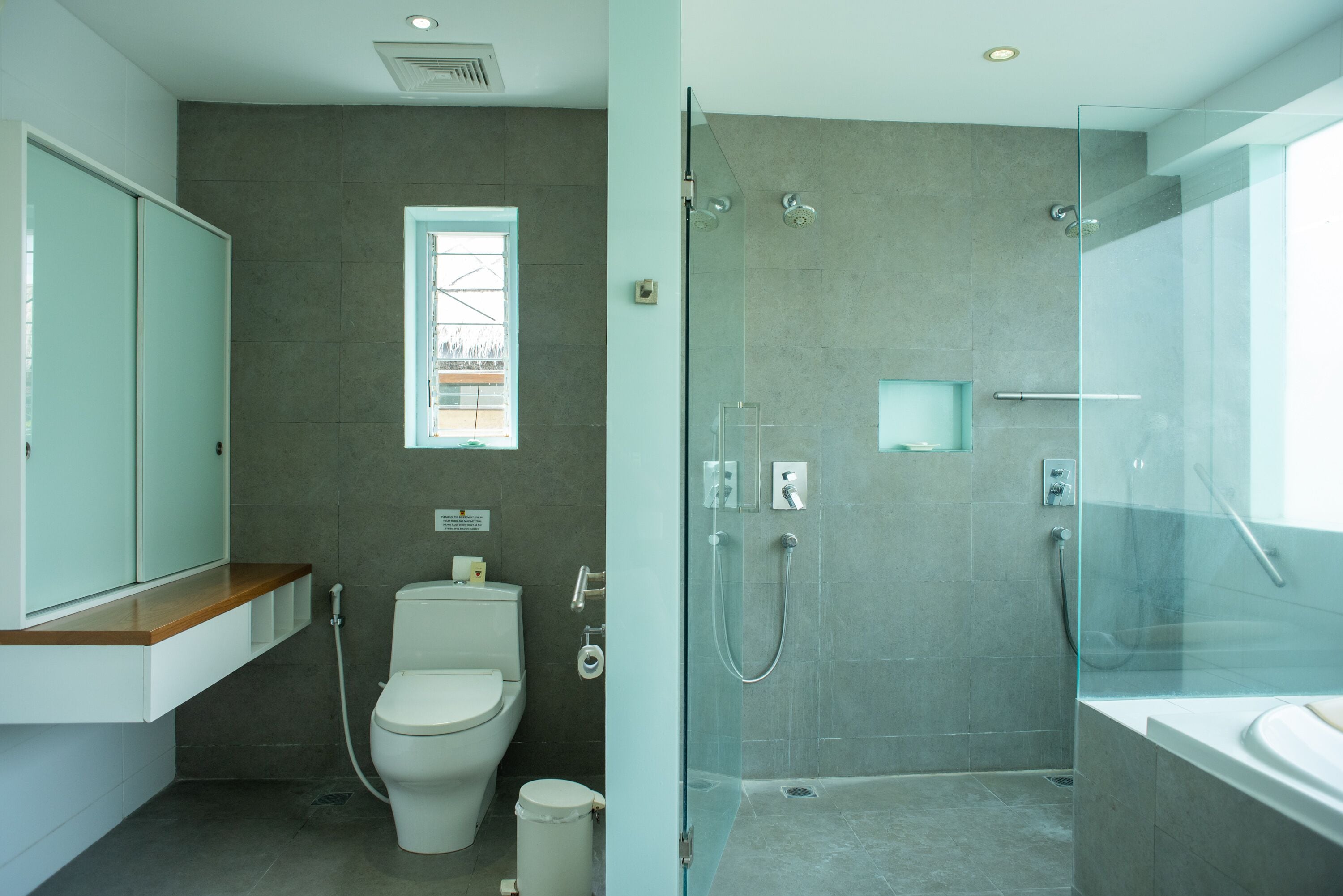 A modern bathroom with a toilet, sink, and shower area.