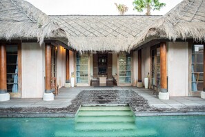 A resort with a pool, thatched-roof structures, and a central seating area. - Sienna Villas Seminyak (Seminyak)