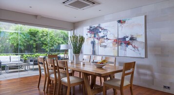 Un comedor moderno con una mesa de madera, sillas y un cuadro abstracto grande en la pared.
