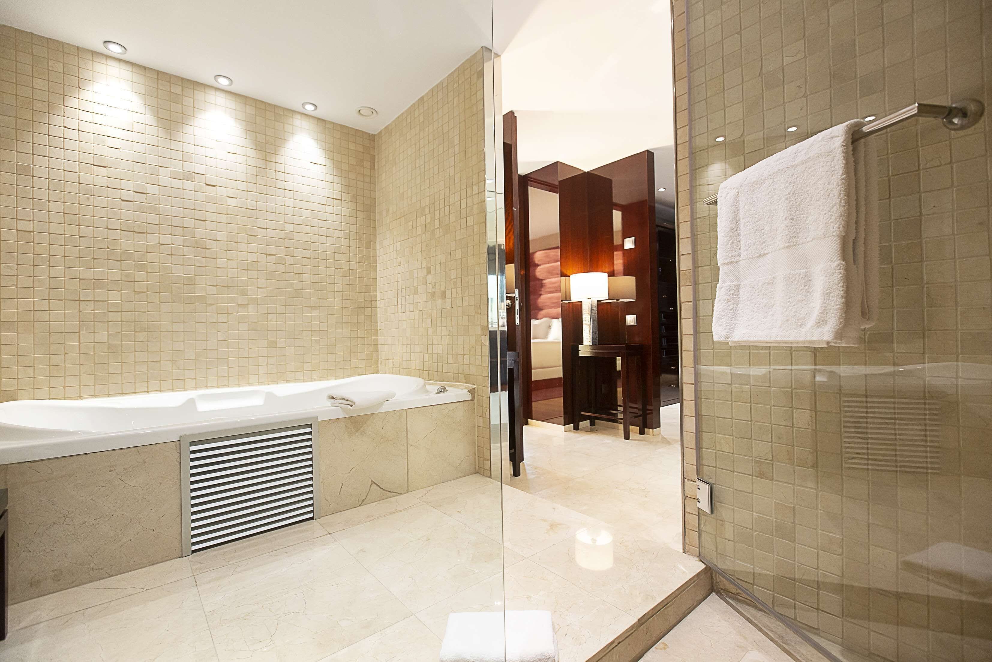 Un baño moderno con bañera, cabina de ducha de vidrio y tocador con espejo.