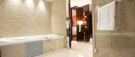 A modern bathroom with a bathtub, a glass shower enclosure, and a vanity with a mirror.