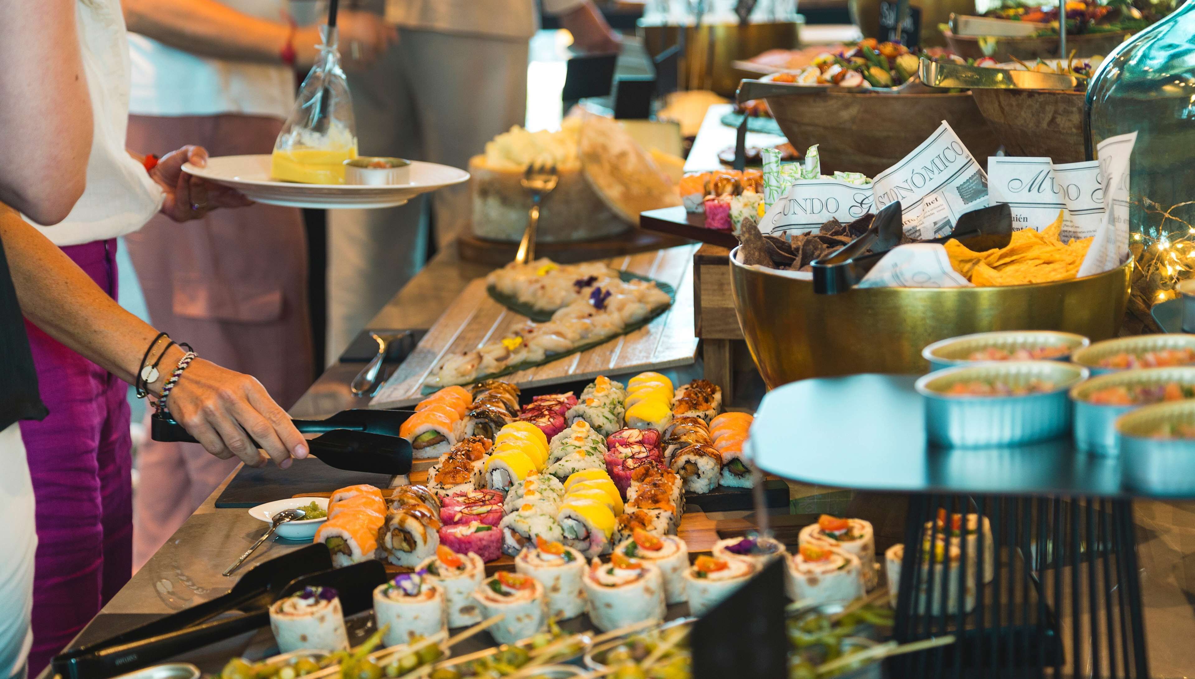 A buffet with various food items including sushi, salads, and desserts.
