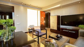 Una sala de estar moderna con un televisor de pantalla plana grande, asientos cómodos y una mesa de centro de vidrio.