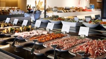 A buffet with various food items and serving utensils.