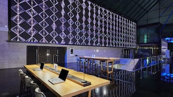 Una sala de conferencias moderna con una larga mesa, portátiles y sillas.