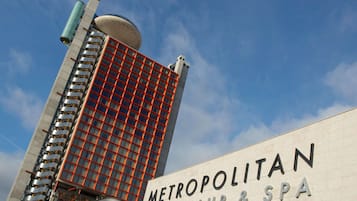 Un edificio moderno con una llamativa fachada de celosía roja y un cartel que dice "METROPOLITAN TOUR & SPA".