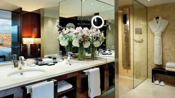 Un baño moderno con dos lavamanos, un espejo grande y una cabina de ducha de vidrio.