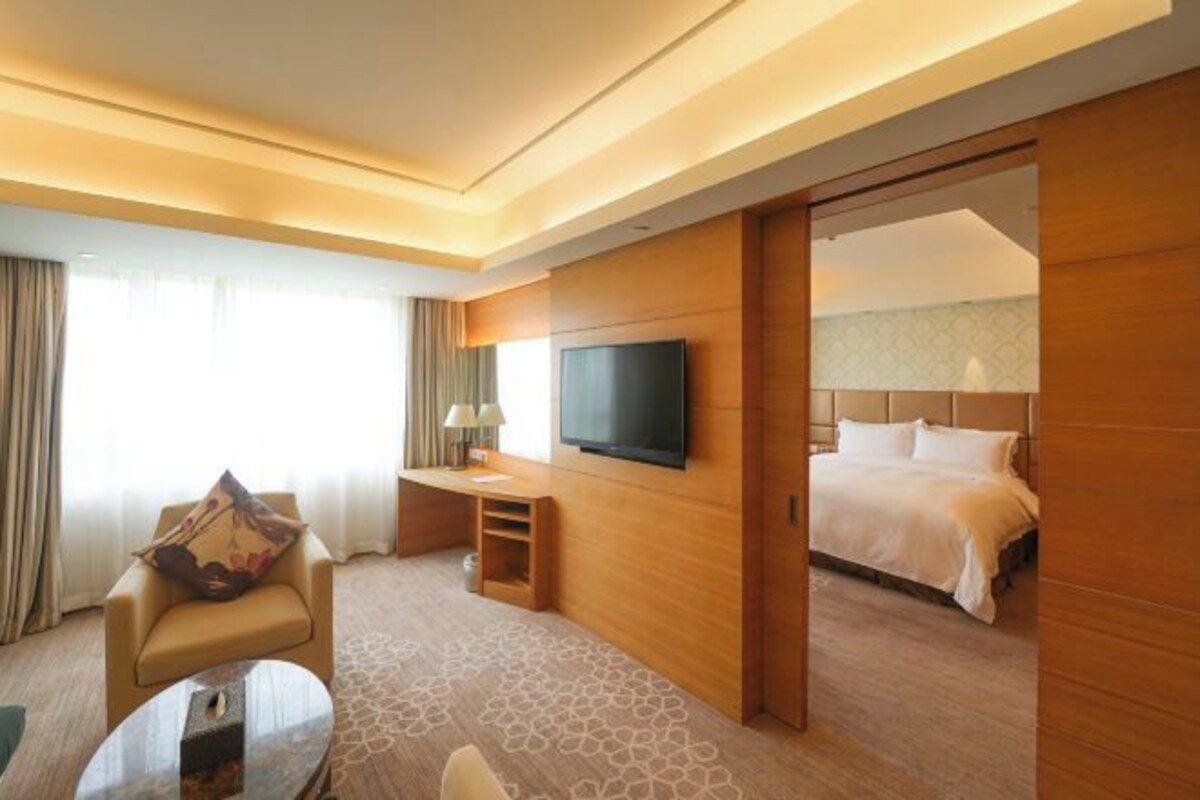 Une chambre d’hôtel avec un lit, une télévision, un bureau et une chaise.