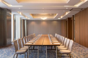 A conference room with a long table, chairs, and a chandelier.