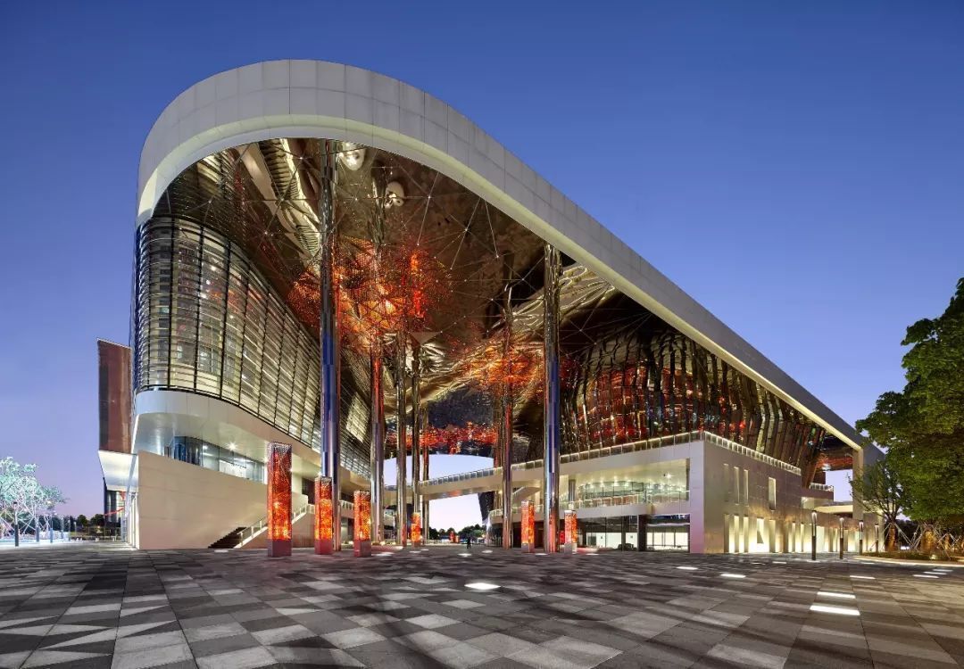 A modern building with a curved facade, large glass windows, and a spacious entrance area.