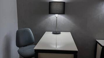Un espacio de oficina pequeño con un escritorio, una silla y una lámpara.