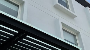 A modern building with multiple windows and a clear blue sky. - Fato Hotel (Querétaro)
