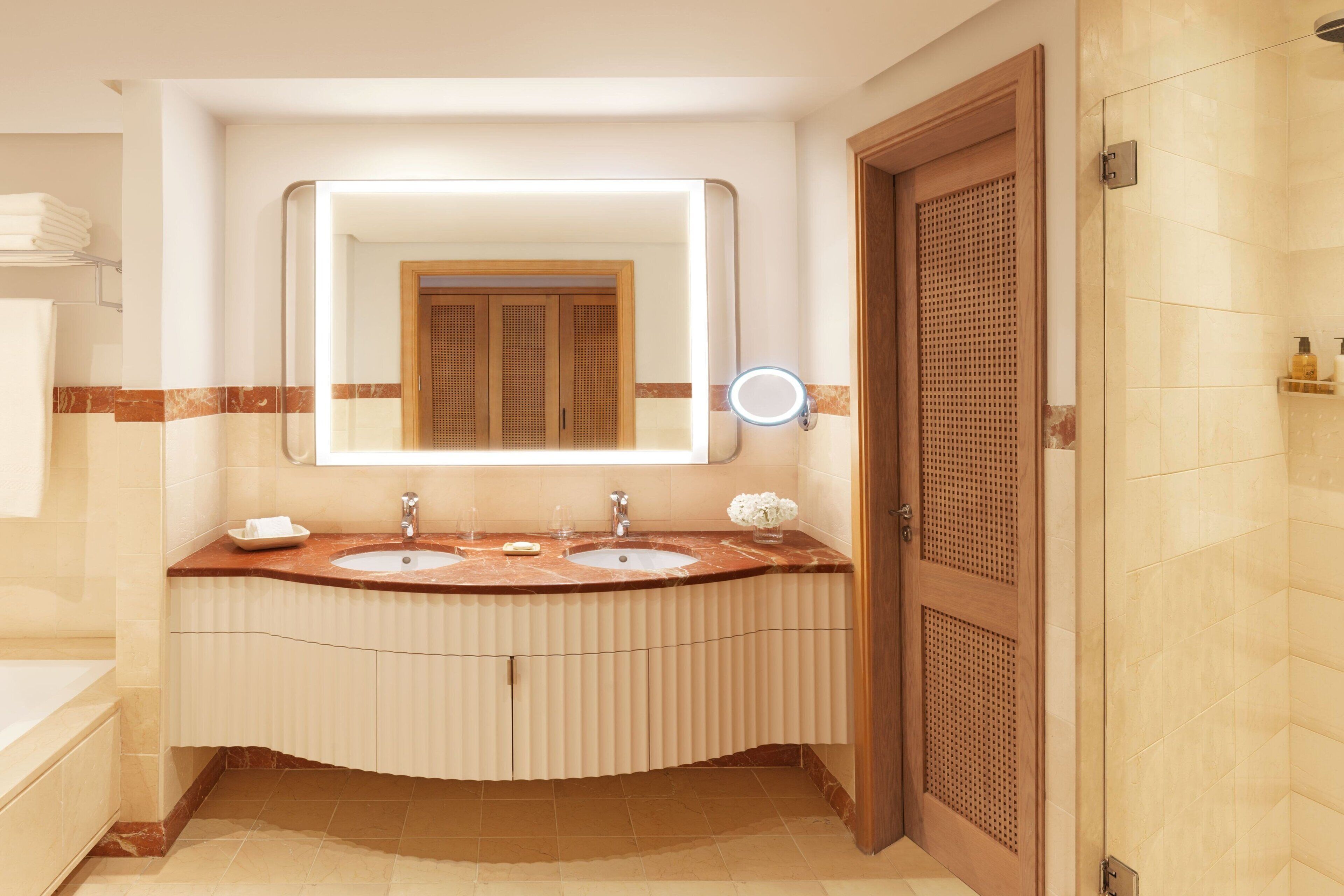 Une salle de bain avec deux lavabos, un miroir et une douche.