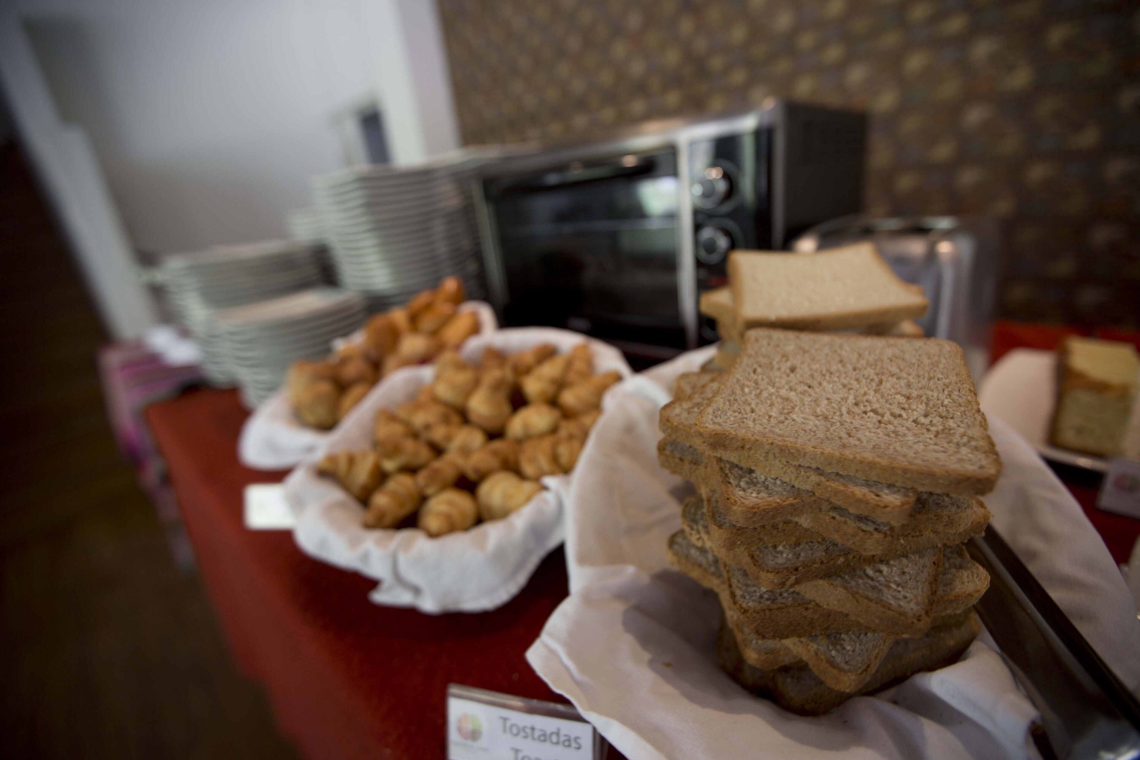 A buffet table with various food items including bread and pastries.