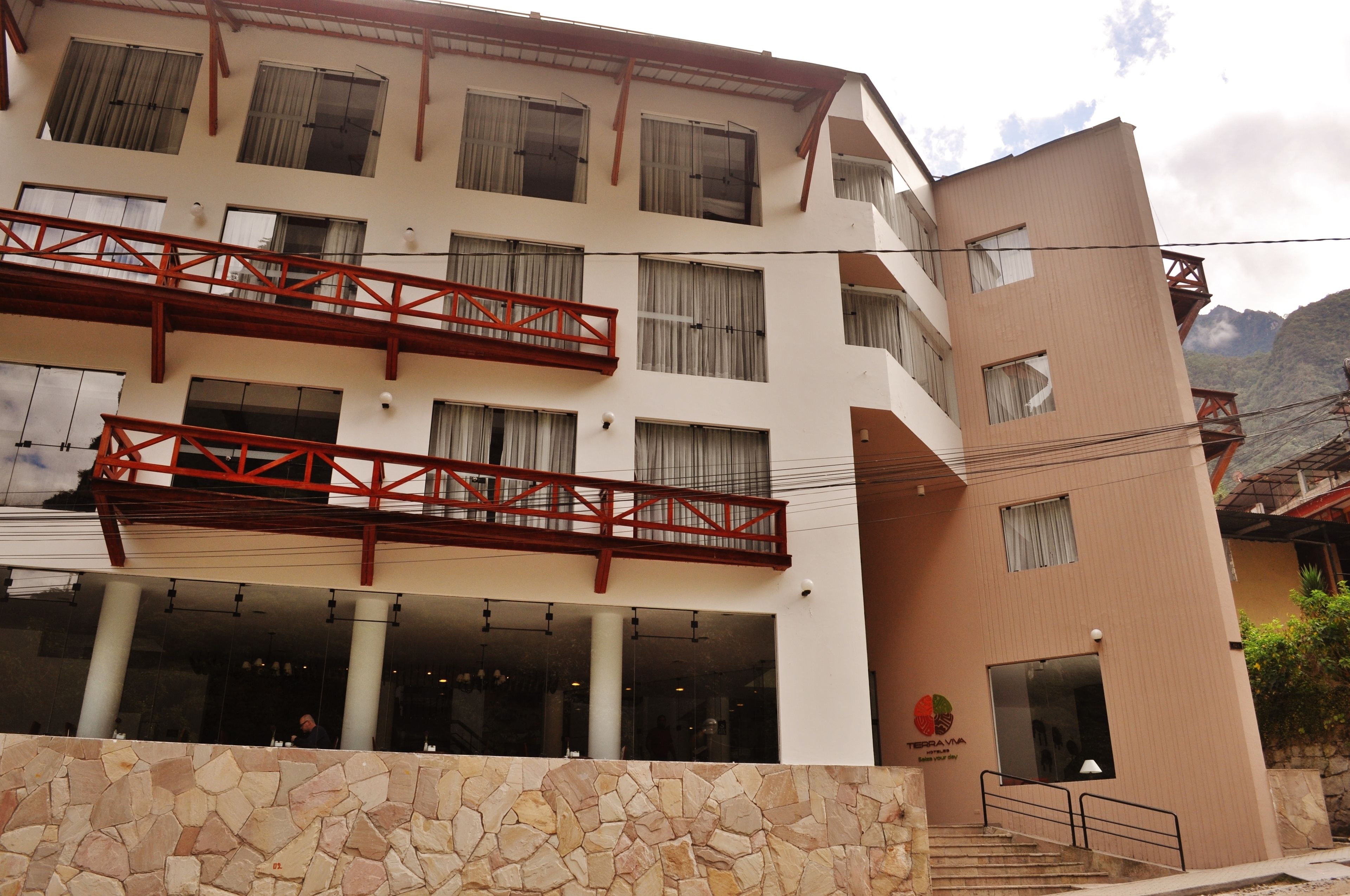 Um hotel com várias andares, fachada de pedra e varandas.