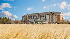 Un hôtel à la façade en briques, doté de nombreuses fenêtres et d’une enseigne indiquant « Garden Inn ».