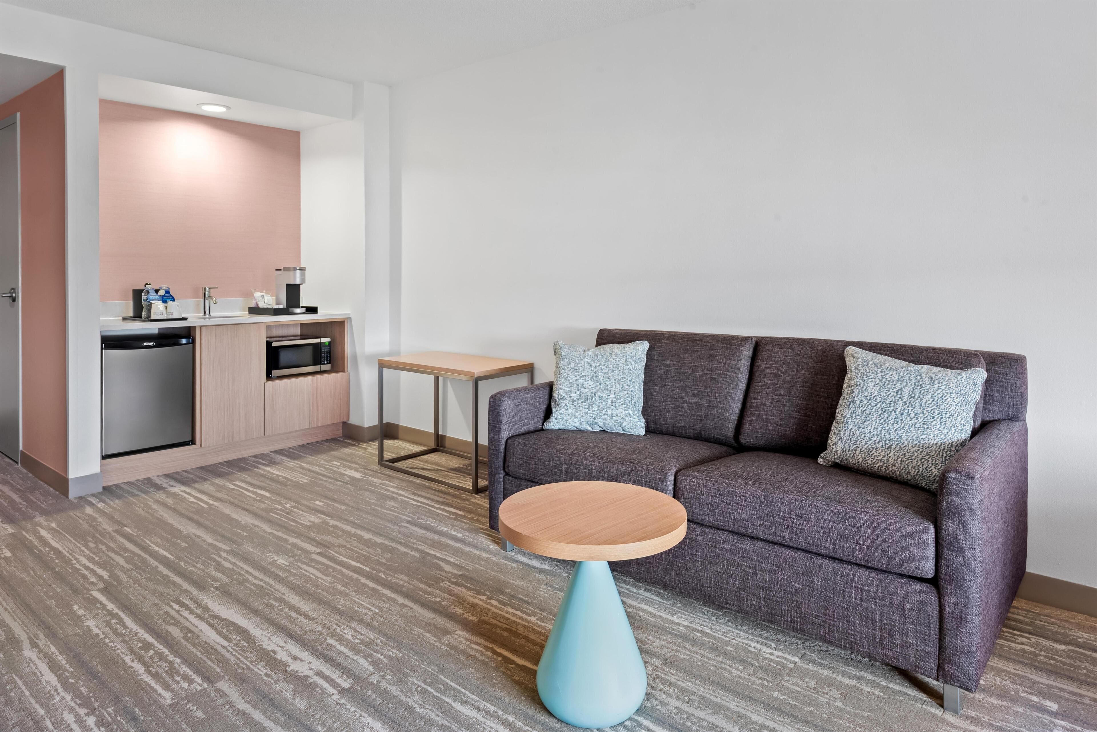 Een moderne woonkamer met een bank, een salontafel en een kitchenette.