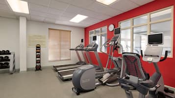 Una palestra con tapis roulant, ellittiche e attrezzi per lo step. Sono presenti anche pesi e una rastrelliera piena di manubri.