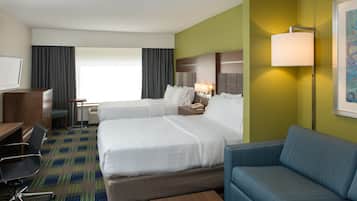Une chambre d’hôtel avec deux lits, un bureau, une chaise, un canapé et une lampe.