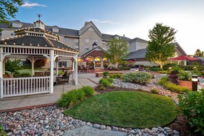 A courtyard with a gazebo, outdoor seating, and a well-maintained garden. - Homewood Suites by Hilton at The Waterfront (Wichita)