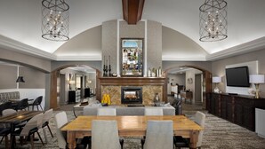 Amplia sala de estar con chimenea, una mesa de comedor y dos candelabros.