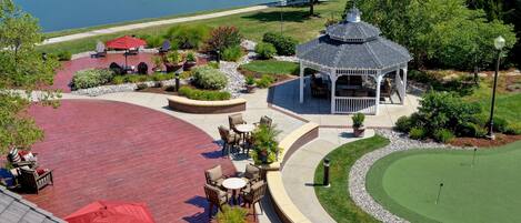 A gazebo, patio seating, and a golf putting area.