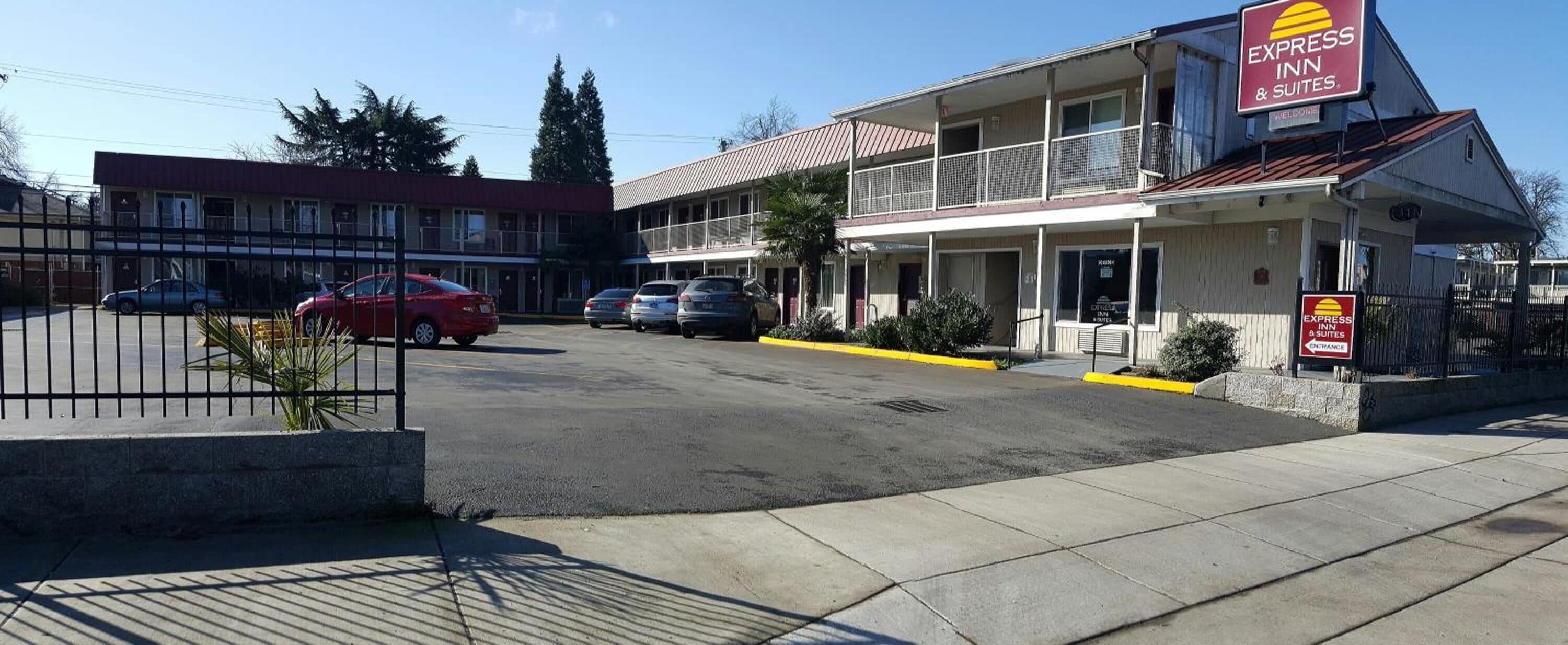 Un motel composé d’un bâtiment à deux étages, d’un parking et d’une enseigne indiquant « Express Inn & Suites ».