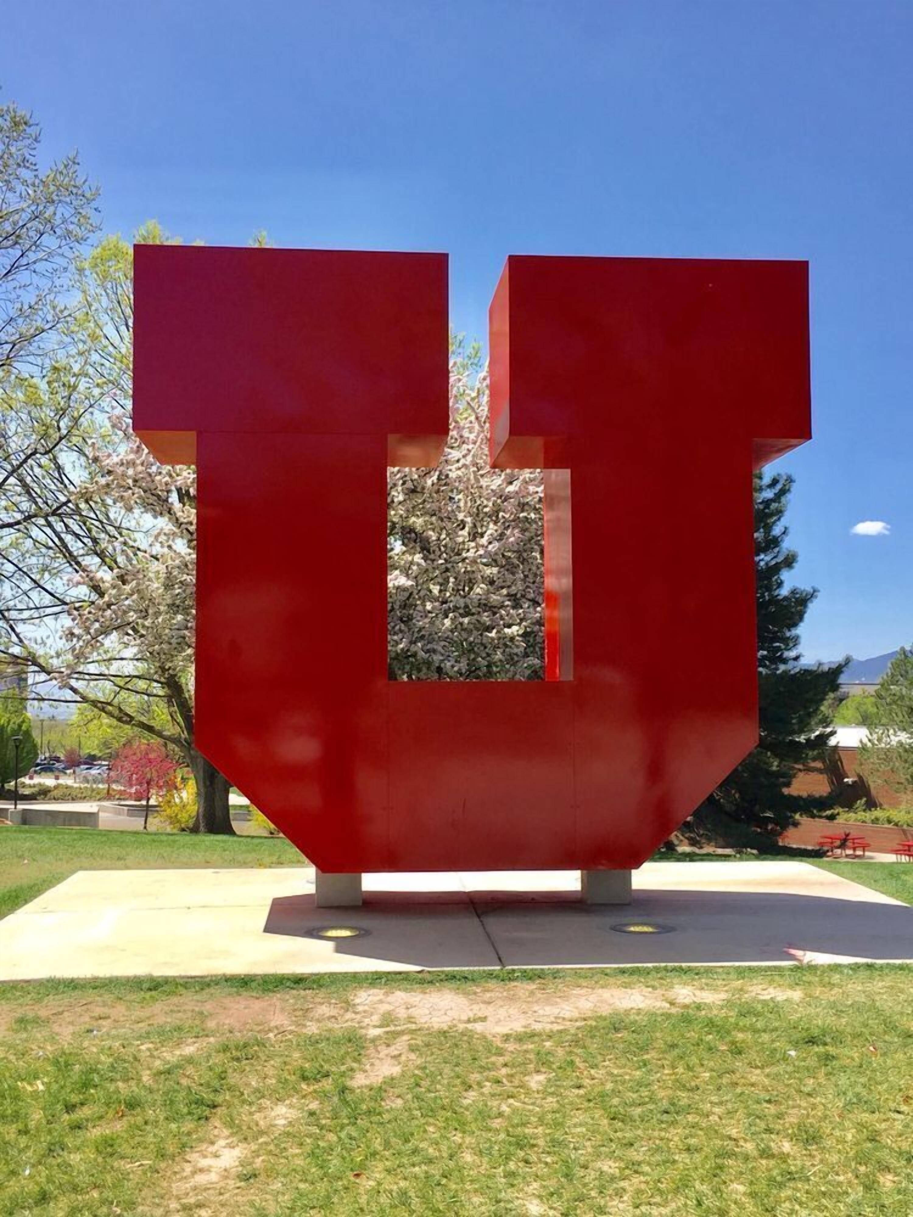 Una escultura abstracta roja en un parque.