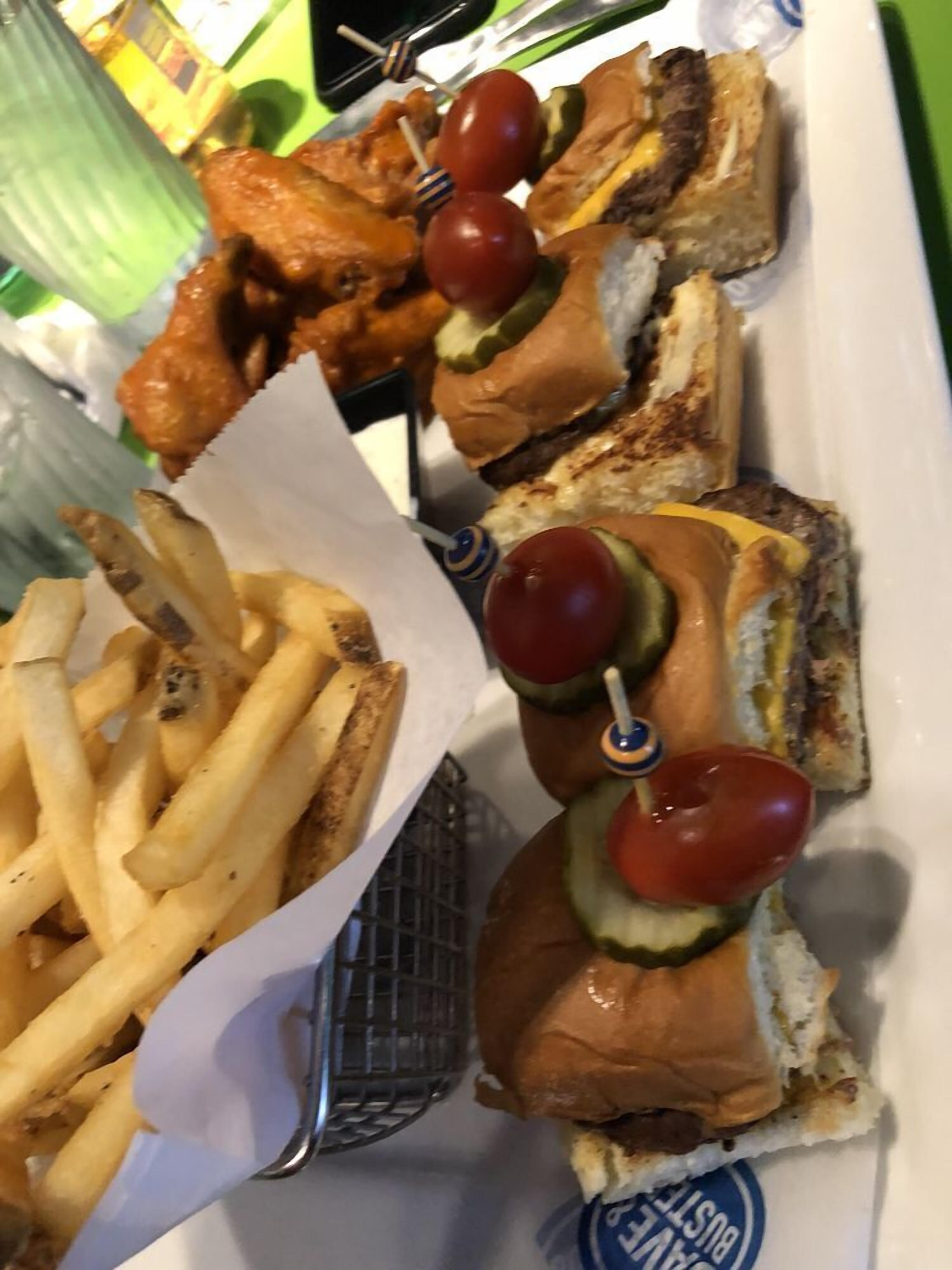 Un plateau avec des brochettes de poulet grillé, des tomates cerises et une portion de frites.