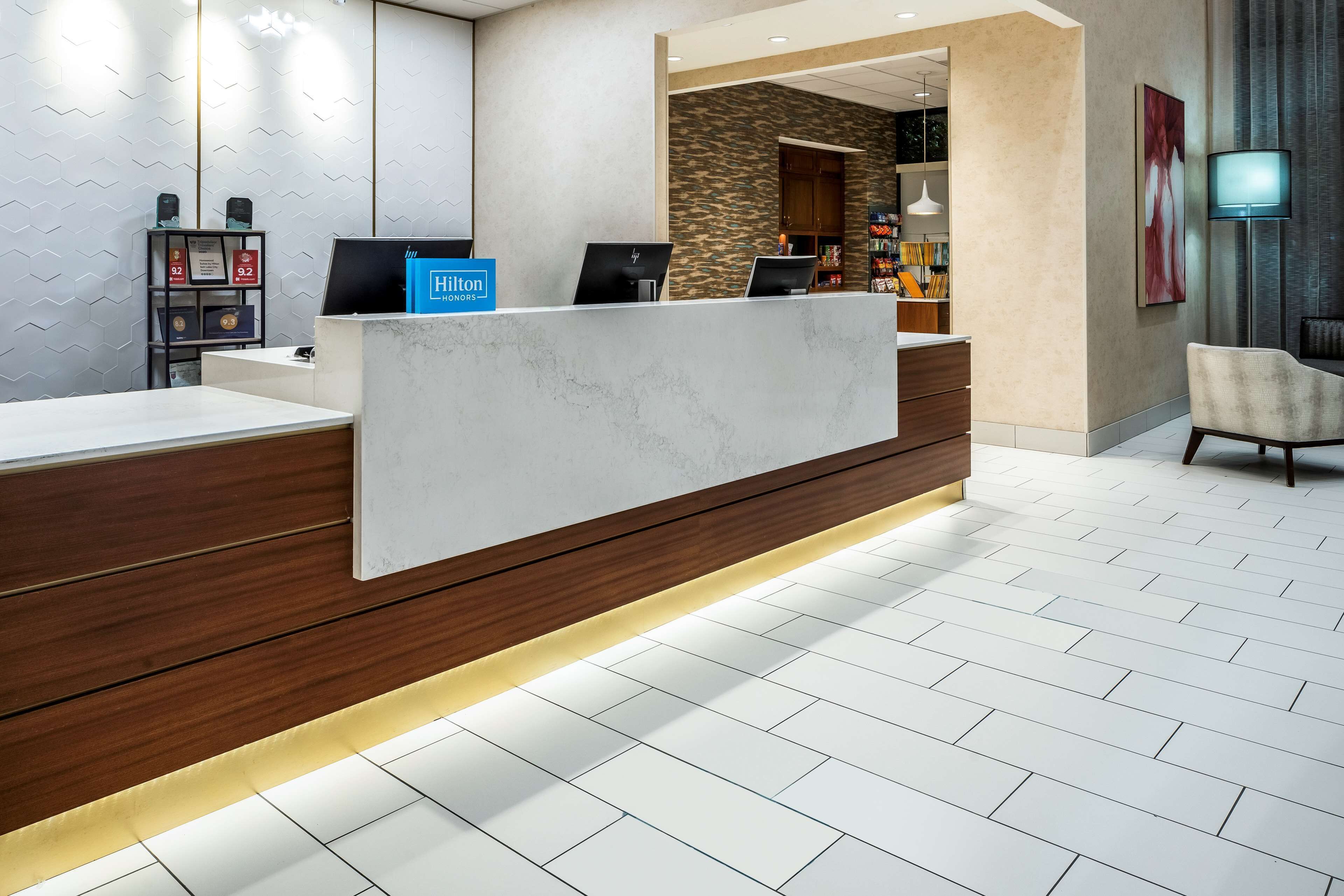 A hotel reception area with a marble counter, wooden paneling, and a stone accent wall.