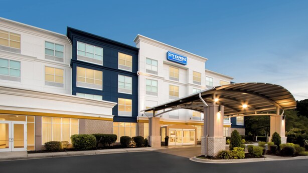 A hotel with a modern design, featuring a covered entrance and a clear sky. - City Express by Marriott Pooler Savannah Airport (Pooler)