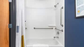 Ducha con cabezal de ducha de mano, barras de apoyo y un perchero.