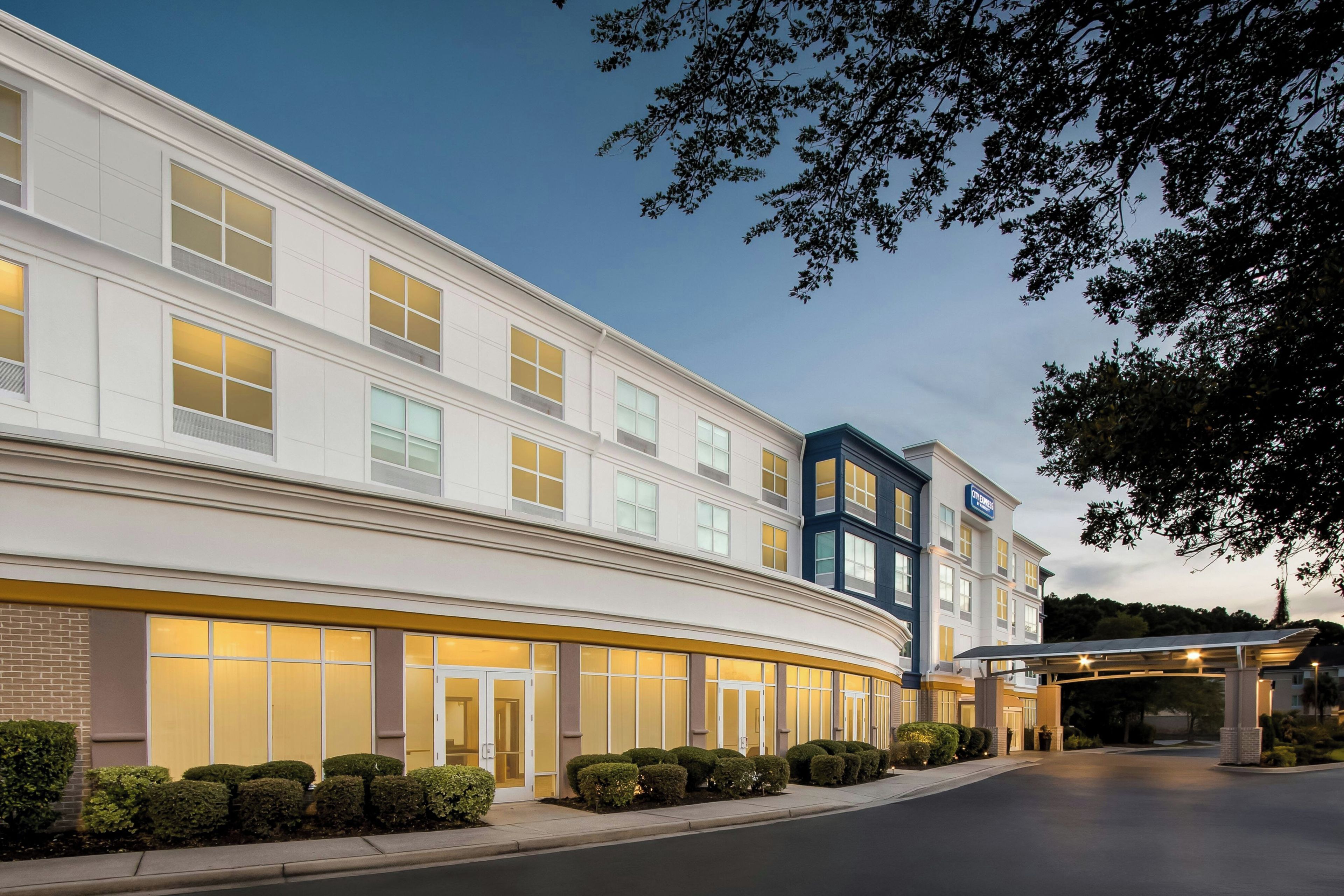 Un hotel con fachada moderna, múltiples ventanales y una entrada bien iluminada.