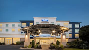 A hotel entrance with a covered walkway, multiple floors, and a sign indicating it's a Marriott property.