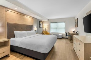 A hotel room with a bed, a desk, a chair, a TV, and a wardrobe. - City Express by Marriott Pooler Savannah Airport (Pooler)