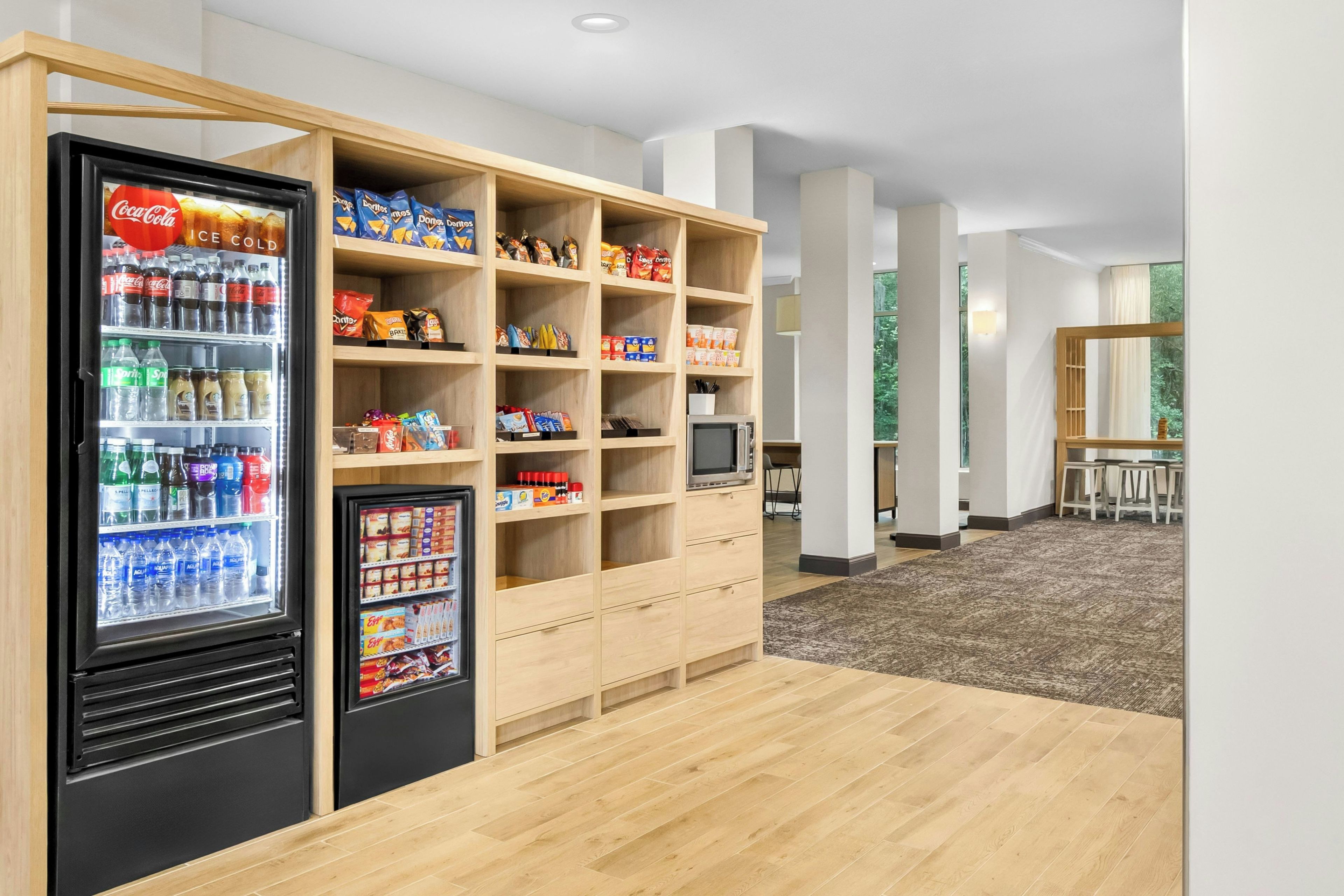 Ein Verkaufsautomatenbereich für Snacks und Getränke, inklusive Kühlschrank und Mikrowelle.